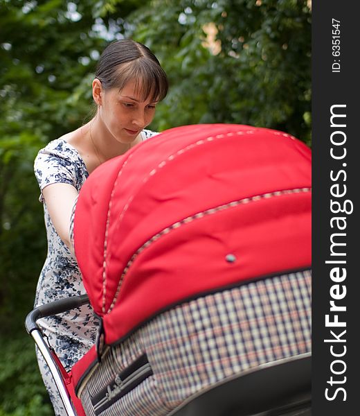 Young woman with red baby carriage. Young woman with red baby carriage