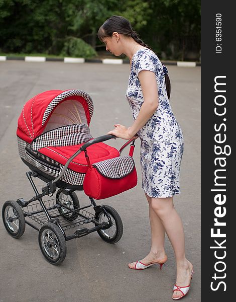 Young woman with red baby carriage. Young woman with red baby carriage