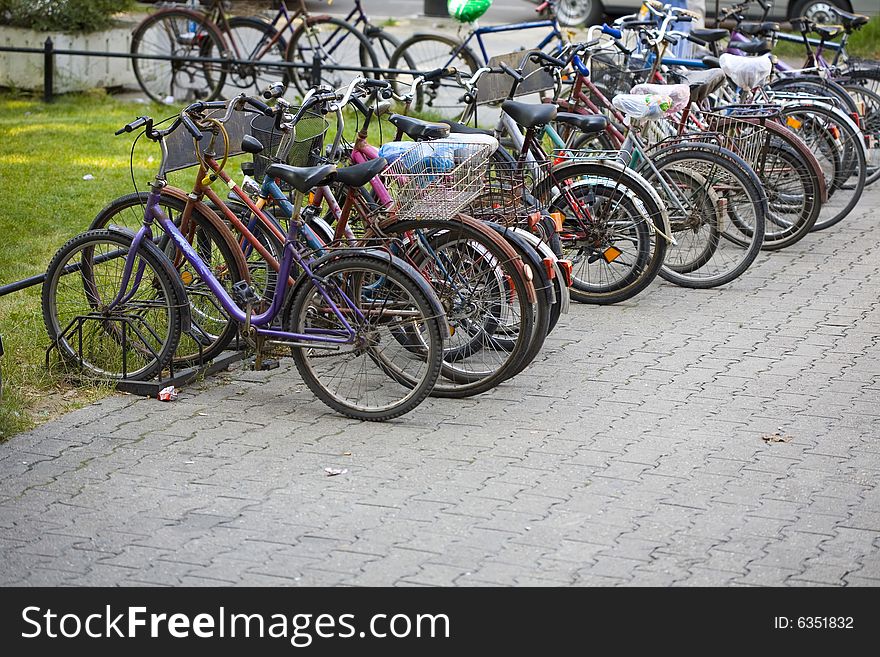 Many Bikes parked on street. Sharp focus on a few first bicycles. Many Bikes parked on street. Sharp focus on a few first bicycles
