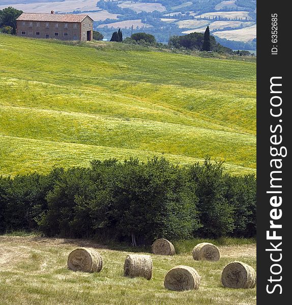 Tuscany countryside, with farm and hayball on the green meadow. Tuscany countryside, with farm and hayball on the green meadow