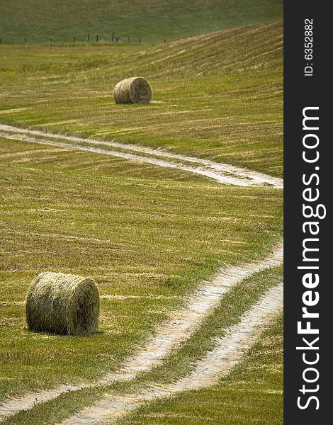 Tuscany countryside, street and hayball on the meadow