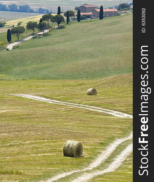 Tuscany countryside, street and hayball on the meadow