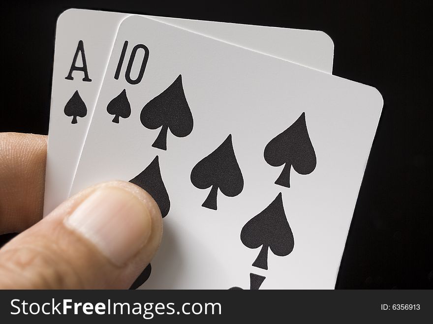 Blackjack cards held by hand against black background. Blackjack cards held by hand against black background