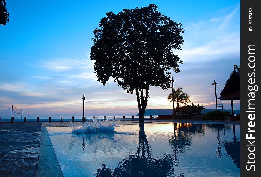 Splash into Pool during dusk at holiday resort. Splash into Pool during dusk at holiday resort