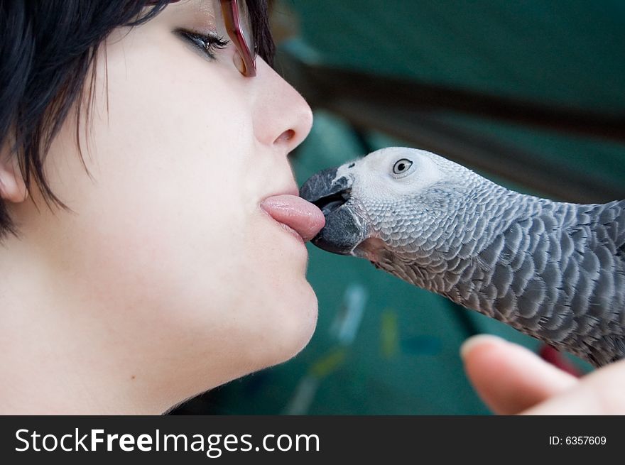 Young woman holding a grey parrot