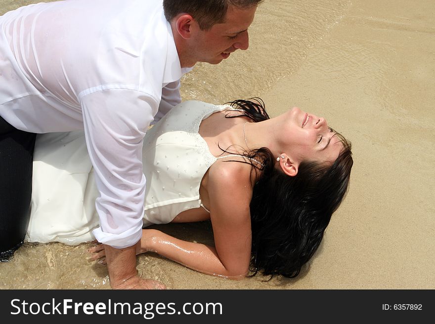 Bride and groom in the ocean during a trash the dress session.
