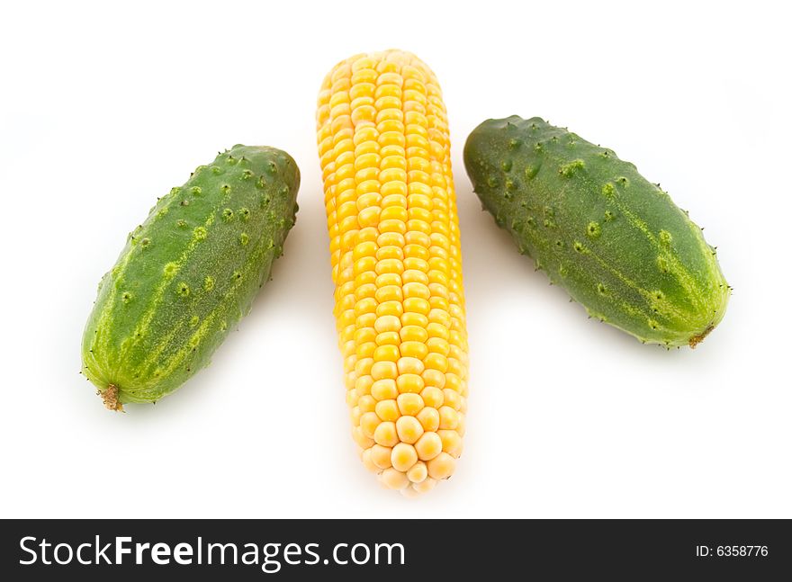 Green 
cucumbers and tasty yellow corn on a white background