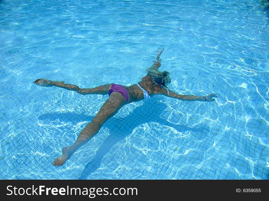 A girl enjoes swimming in the pool