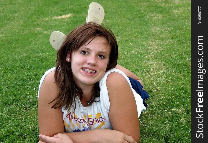 A picture of a young teen girl laying in the grass. A picture of a young teen girl laying in the grass.