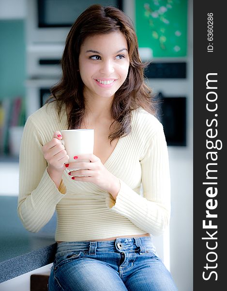 A young woman having coffee in the kitchen. A young woman having coffee in the kitchen