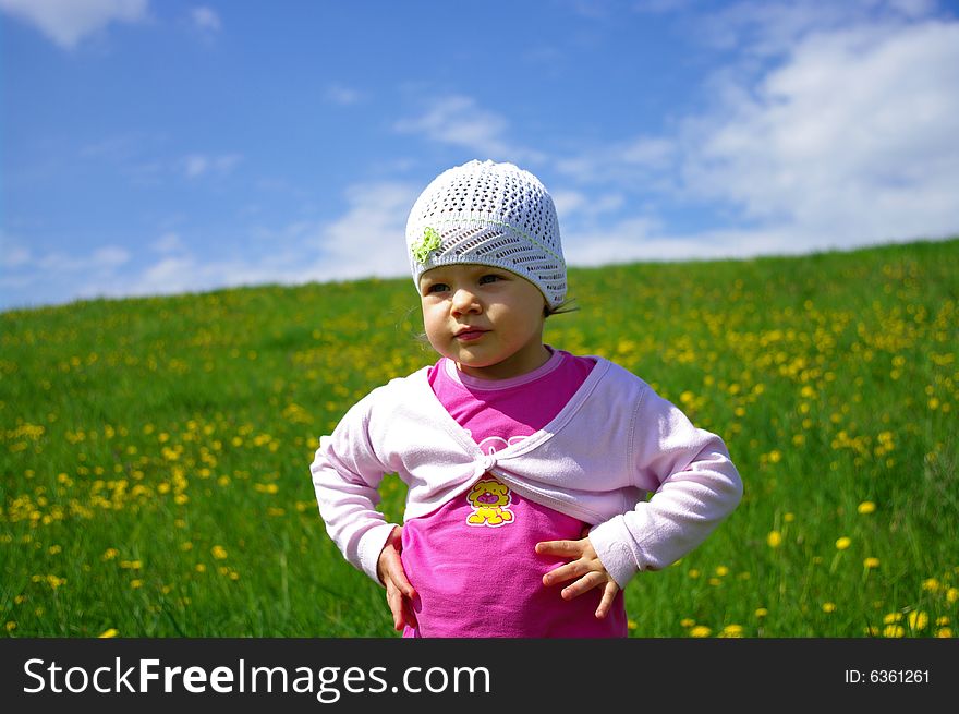 Girl on grassland in the midst of flowers entertaining