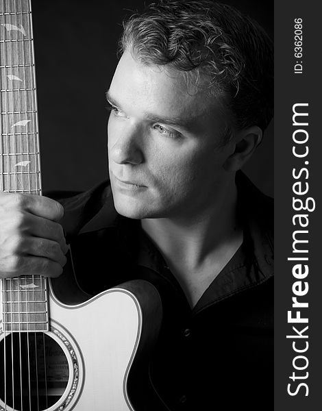 Portrait of young musician holding his guitar