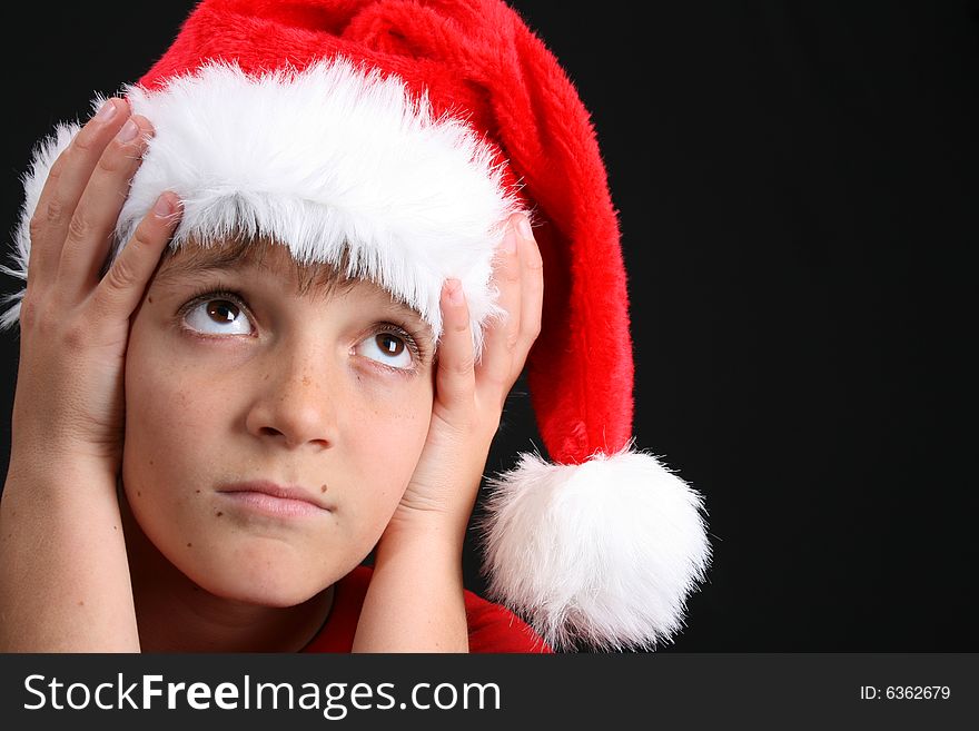Young boy wearing a red shirt and christmas hat. Young boy wearing a red shirt and christmas hat