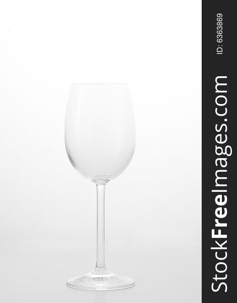 A transparent wine glass on a grey background