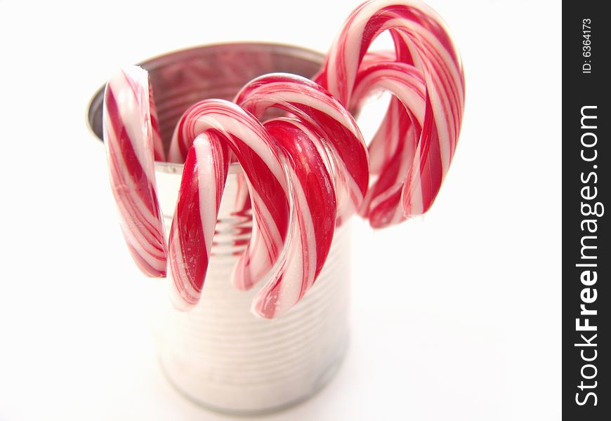 Stripped red and white candy canes over white background