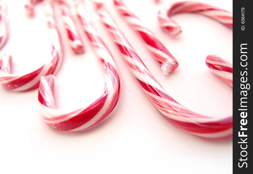 Stripped red and white candy canes over white background