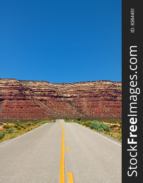 An image of a desert highway leading into amazing mountains. An image of a desert highway leading into amazing mountains