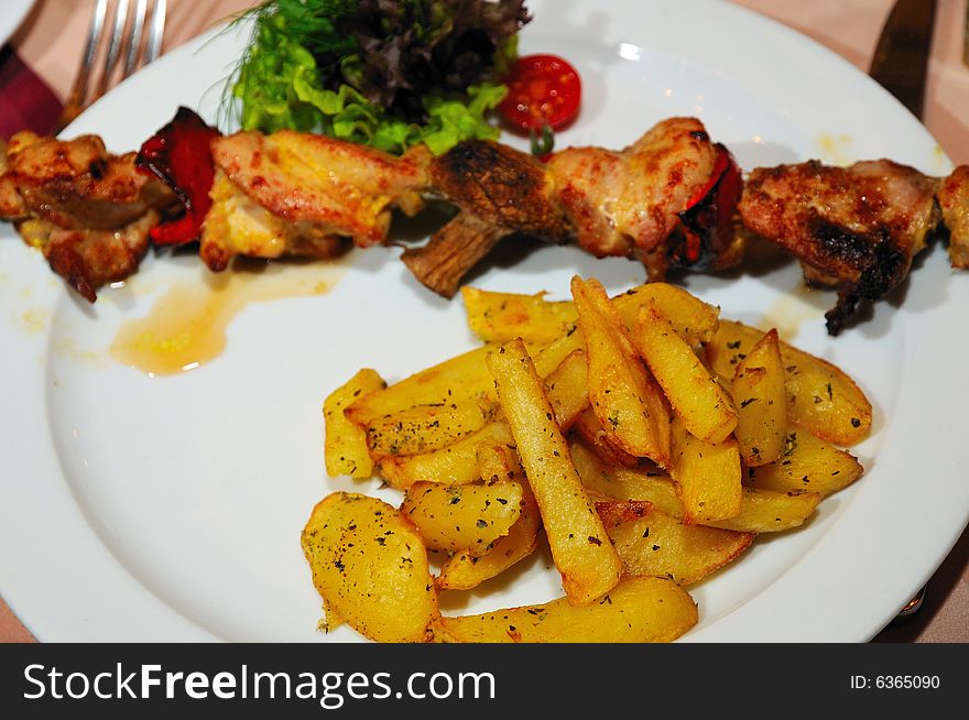 Grilled chicken with potato and mushrooms focus on potato