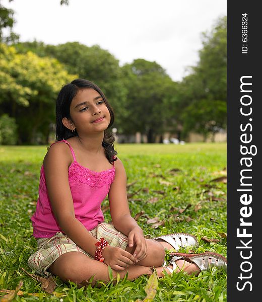 Asian girl of indian origin sitting in a park. Asian girl of indian origin sitting in a park