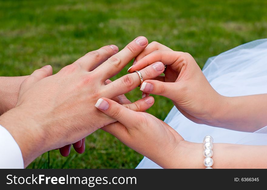 Fiancee puts a ring on a finger to fiance. Fiancee puts a ring on a finger to fiance