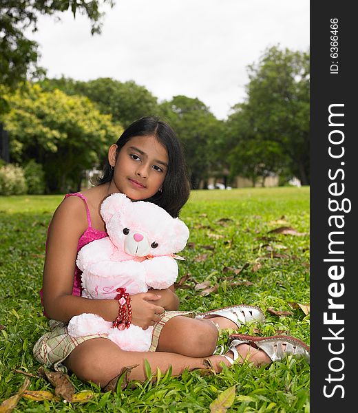 Asian girl of indian origin in a park with her teddy bear. Asian girl of indian origin in a park with her teddy bear