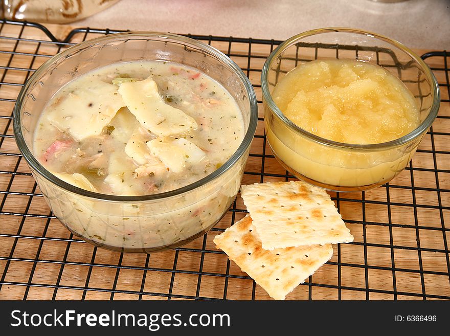 Chicken dumplings in kitchen or restaurant.  Applesauce, crackers.