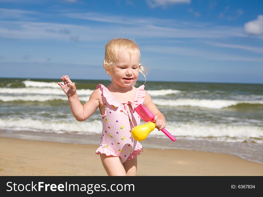 Small girl with toys on the seashore. Small girl with toys on the seashore