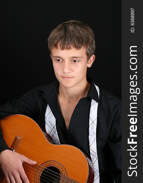 Teenage male in casual attire playing guitar. Teenage male in casual attire playing guitar