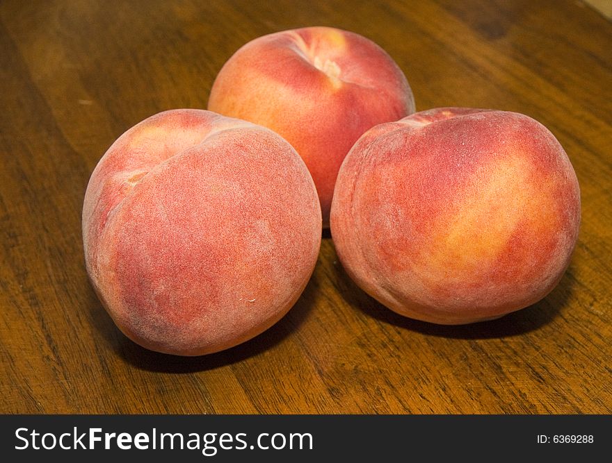 Three Fresh Peaches on a wood table. Three Fresh Peaches on a wood table