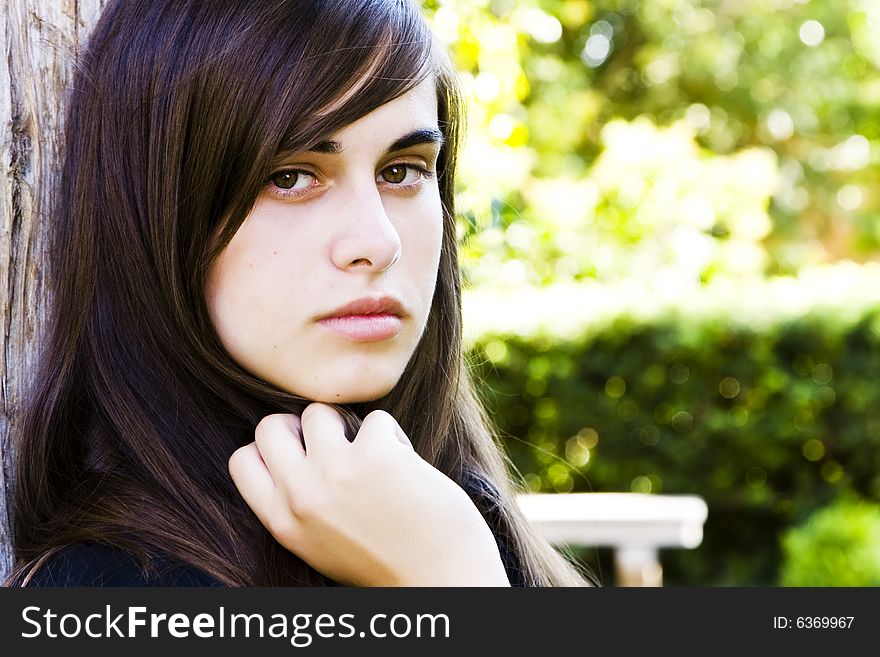 Young staring woman with green nature color as background