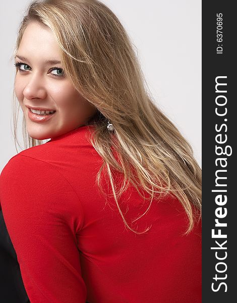 Portrait of beautiful blonde woman wearing a red top. Not isolated