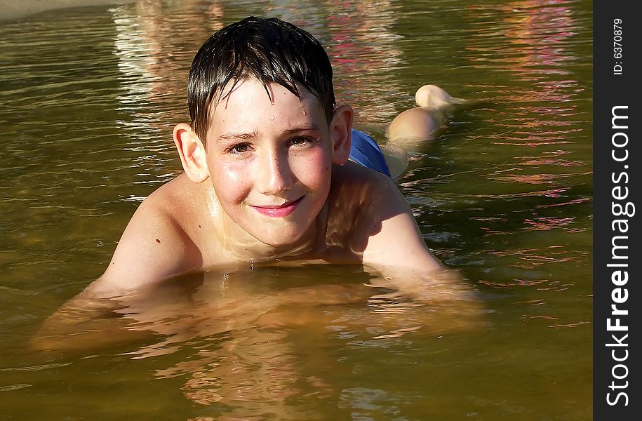 A boy laying in a shallow water of lake. A boy laying in a shallow water of lake