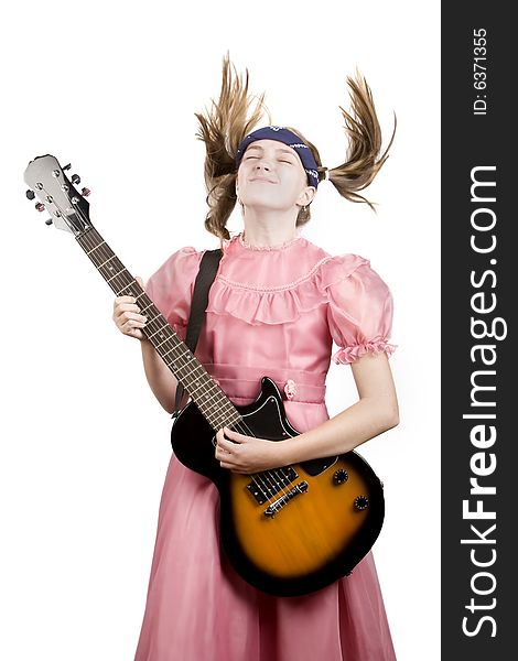 Young girl in a pink dress head-banging with an electric rock guitar. Young girl in a pink dress head-banging with an electric rock guitar