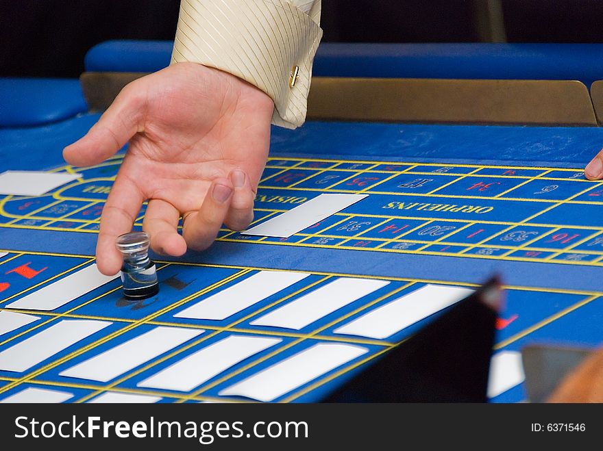 Croupiers hands under the blue roulette table. Croupiers hands under the blue roulette table