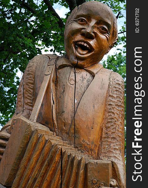 A wooden musician playing an accordion