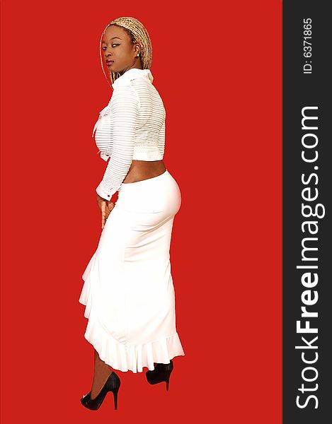 An busty young Jamaican girl in a white long skirt and top, long blond hair standing in an studio for red background. An busty young Jamaican girl in a white long skirt and top, long blond hair standing in an studio for red background.