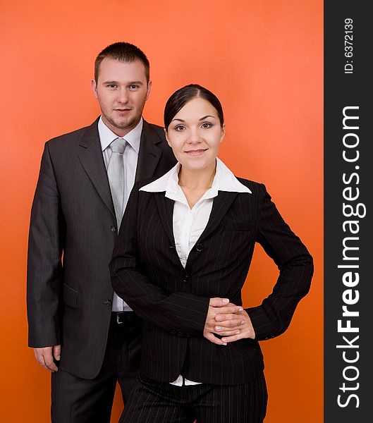 Woman and man in team standing on orange background. Woman and man in team standing on orange background