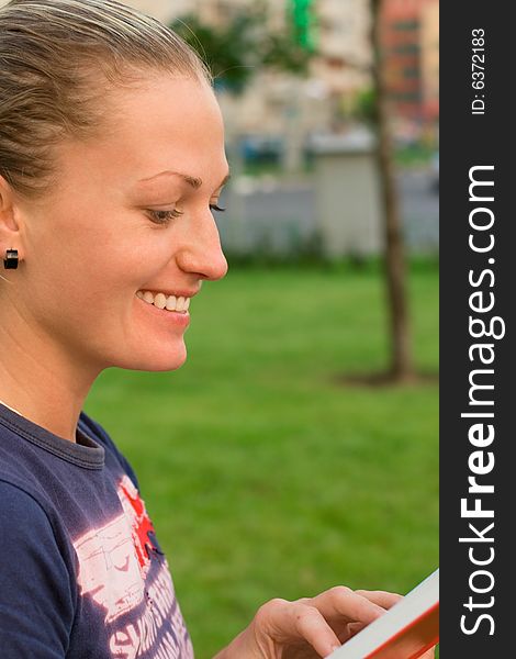 Portrait of attractive woman reading in the park