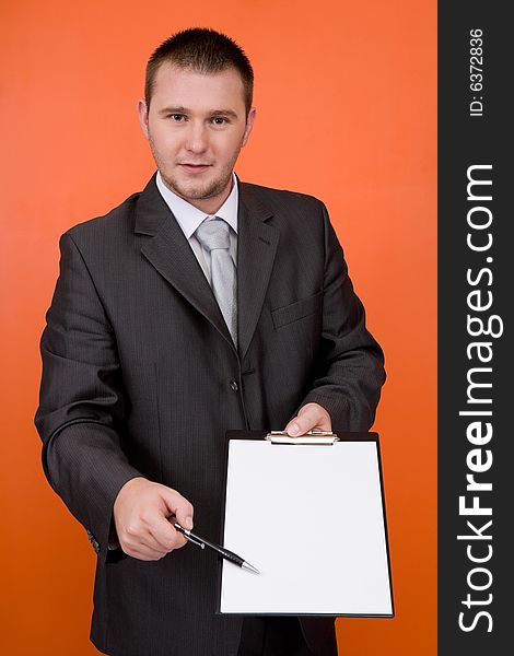 Casual guy standing with banner on orange background. Casual guy standing with banner on orange background
