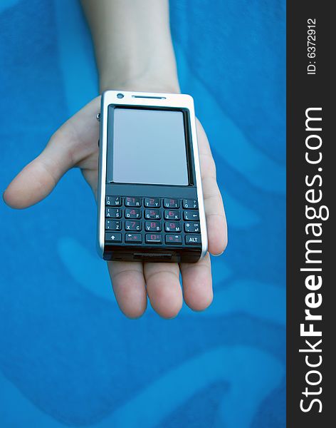 Cellular (mobile) phone on girl's palm reaching forward. Cellular (mobile) phone on girl's palm reaching forward