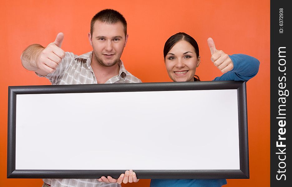 Casual couple together standing on orange background. Casual couple together standing on orange background