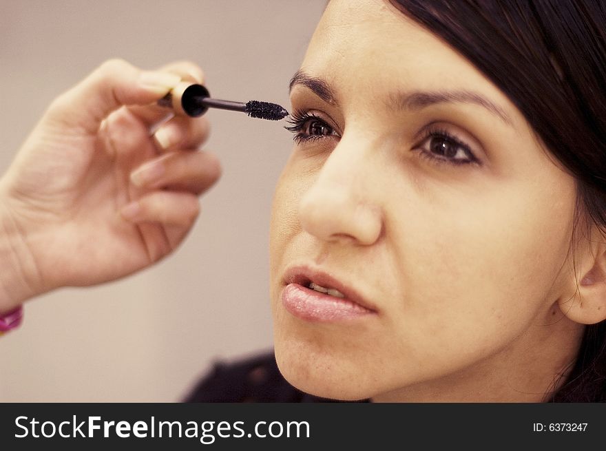 Young woman being make up by a makeup artist.
