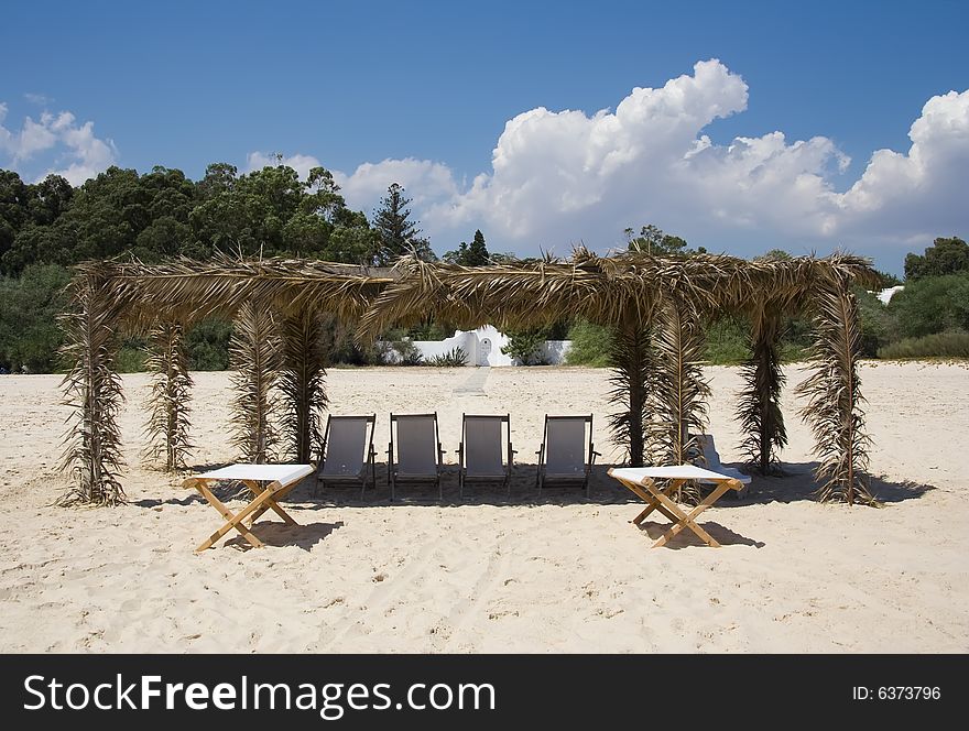 Canvas Chairs on tropical beach over blue sky