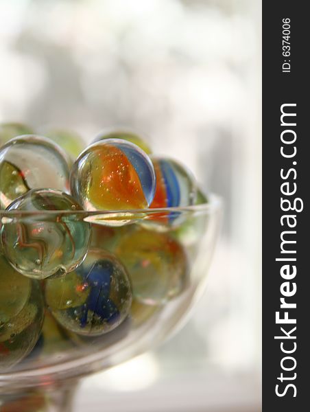 A glass is full of colorful marbles. A glass is full of colorful marbles.