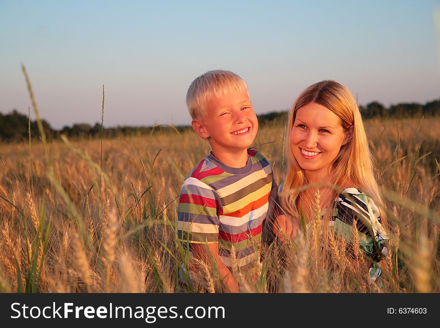 Mother and son   on a wheaten field