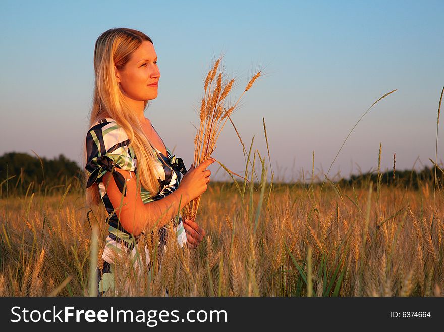 Young woman with earns  on a wheaten field