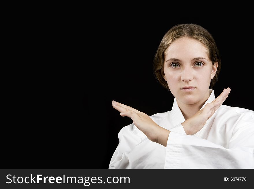 Young girl in a karate pose on black