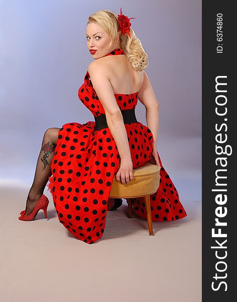 Cute pinup girl in red dress with tattoo