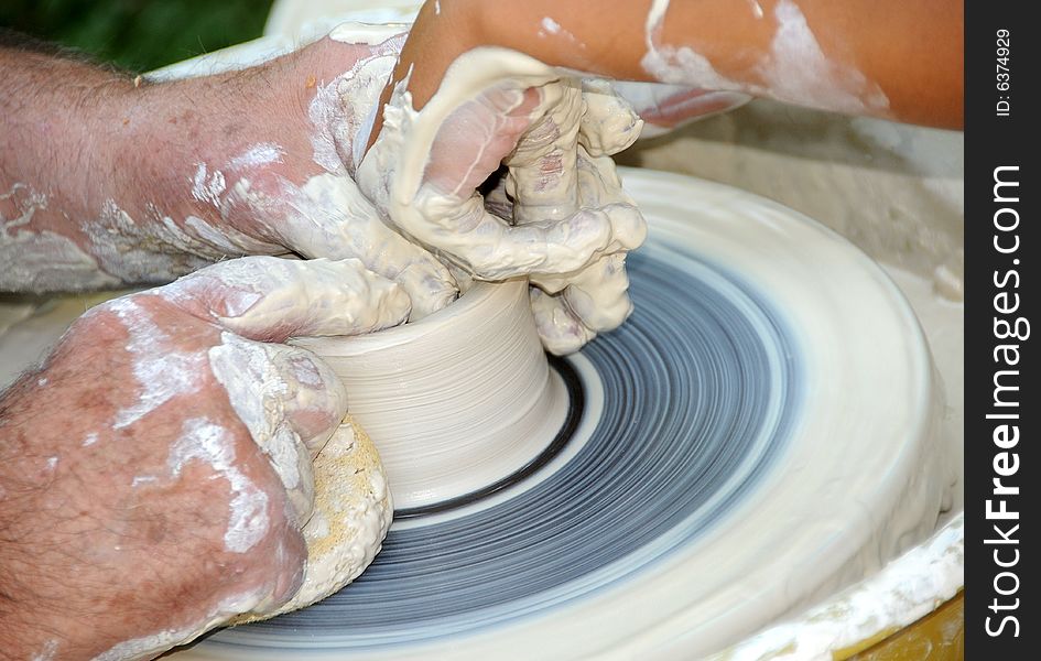 Teacher Showing Student how to make Pottery on a Turning Wheel. Teacher Showing Student how to make Pottery on a Turning Wheel