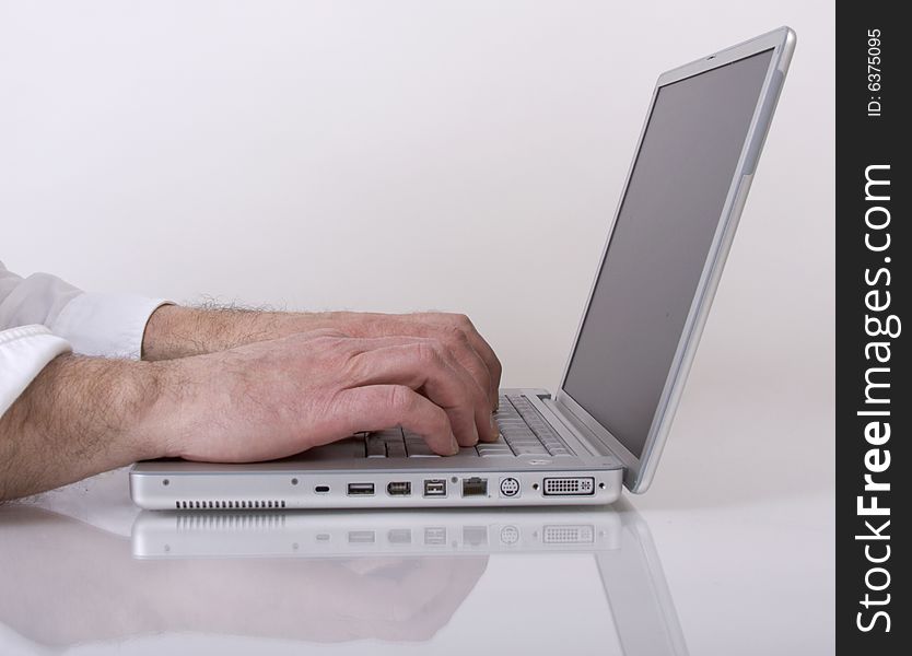 Man's hands typing on a laptop computer. Man's hands typing on a laptop computer